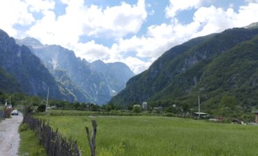 Theth valley surrounded by Albanian Alps mountains on a clear summer day