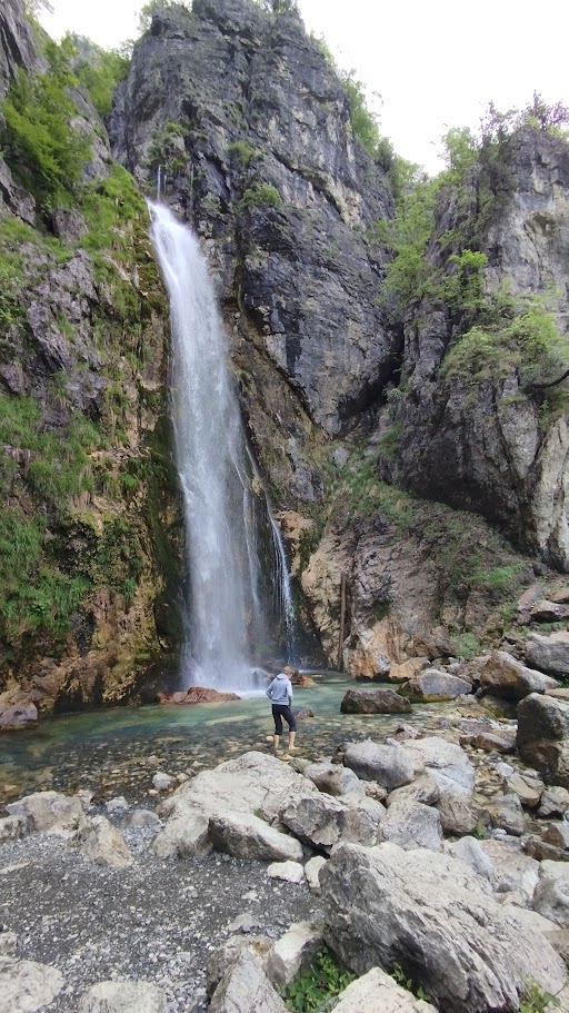 Grunas waterfall cascading through forested gorge in Theth National Park
